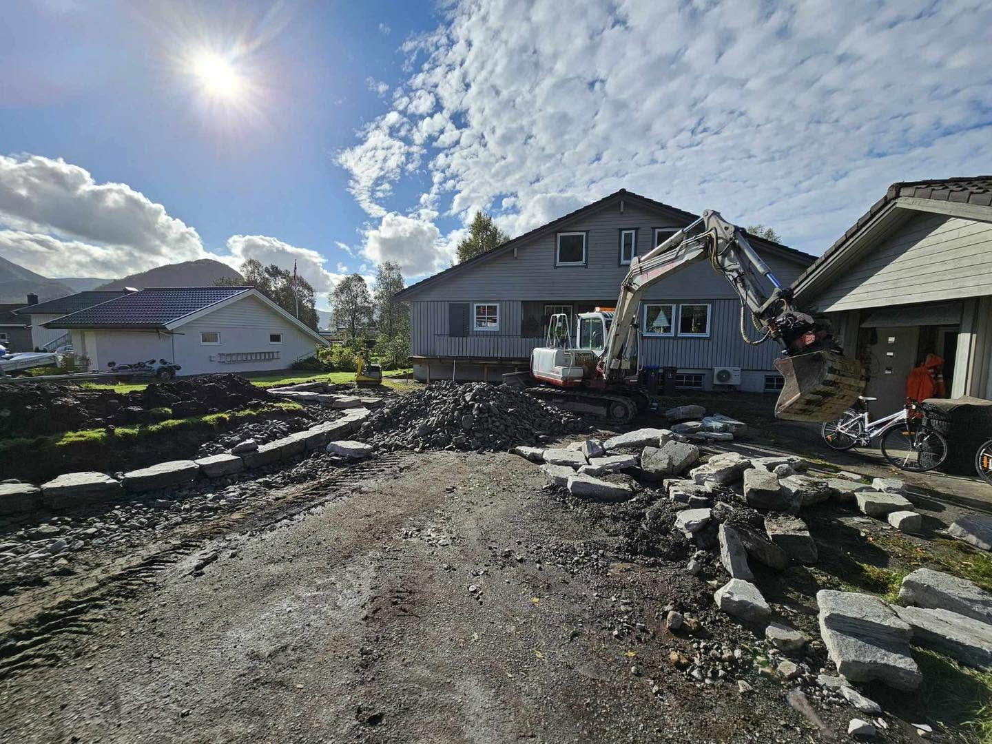 Gravemaskin og natursteinsmuring ved bustad frå Aasemyr Anleggsservice