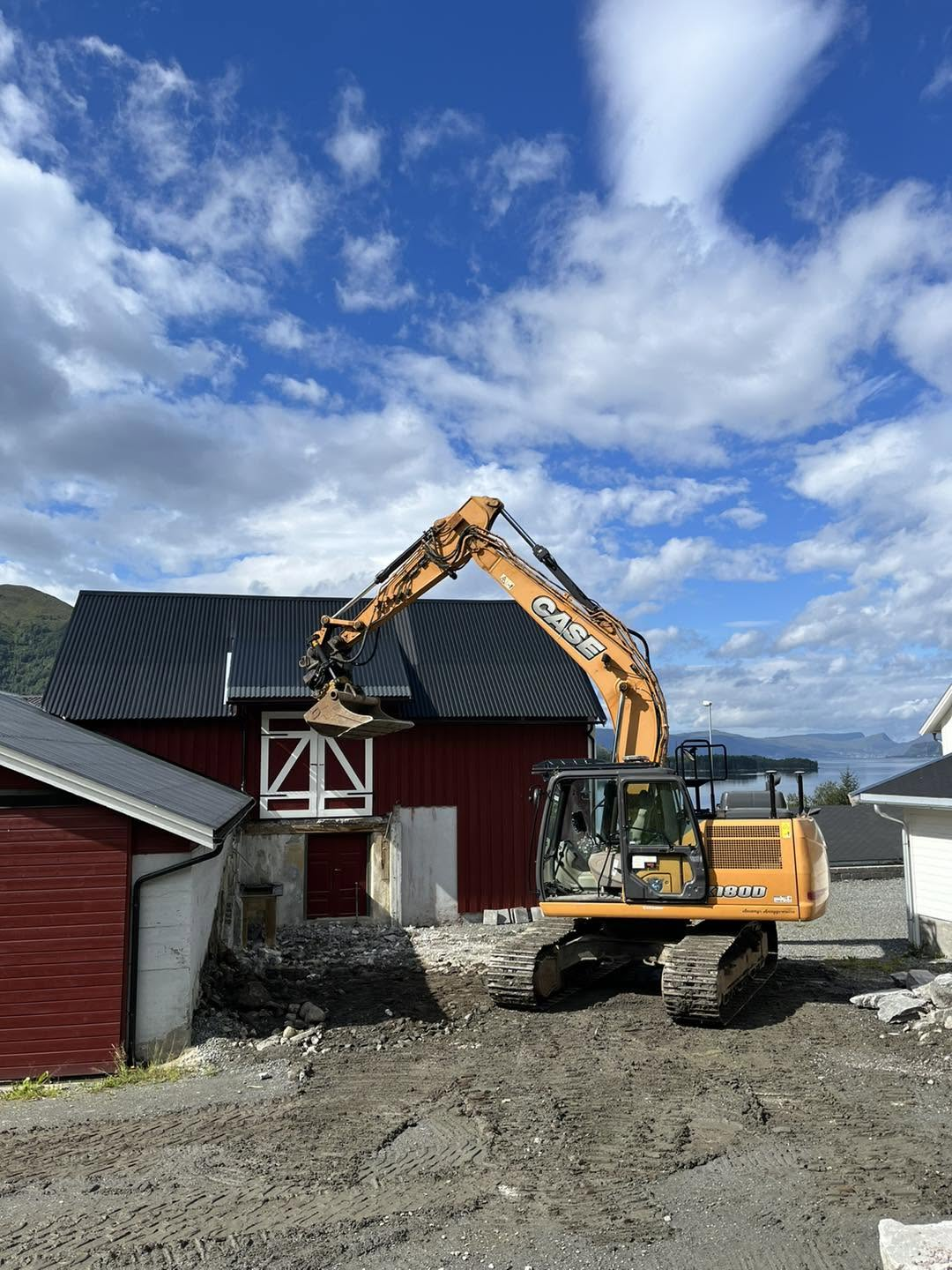 Gravemaskin riv og grev ut den gamle løerampa ved den raude låven på garden